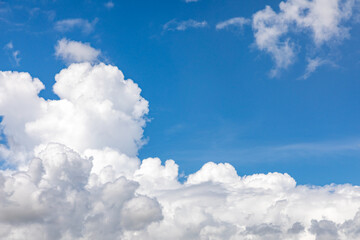 Naklejka na ściany i meble A horizontal shot of bright blue sky with puffy white clouds.
