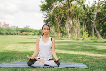 young woman have a beautiful body, Playing yoga in an elegant posture, in the green park, a concept to people's recreation and health care concept. blurred background