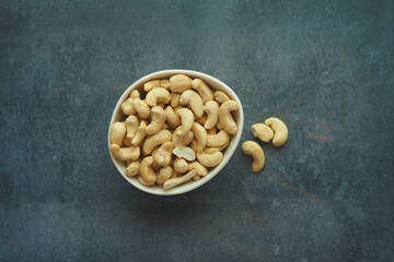 cashew nuts in a small bowl on black color background 