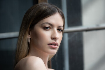 Beautiful young woman portrait in bright sunlight, contrast on the skin, bright highlights on the face
