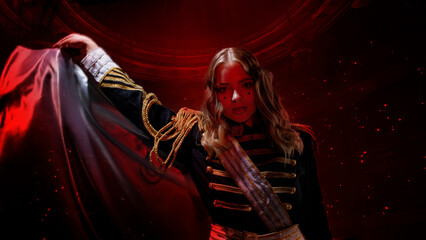A glamorous blonde in a carnival uniform with epaulettes, waving a raincoat, the host of the show,