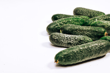 a lot of green cucumbers on a white background