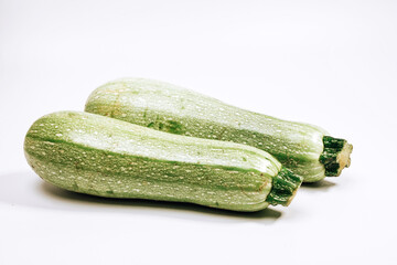 two green zucchini on a white background