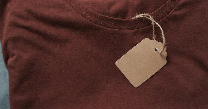 Video of flat lay of multi coloured t shirts with tags and copy space on white background