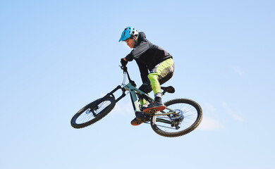 Fototapeta na wymiar Bicycle, man and jump in blue sky for competition, freedom and adventure with mockup space. Athlete, sports and bike in air for action, cardio race and courage for stunt performance, power or contest