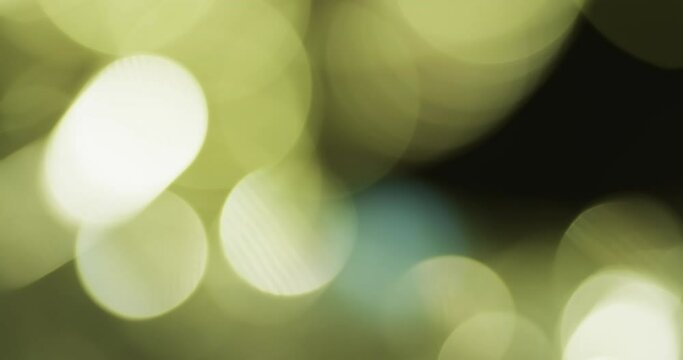 Video of flickering white and green bokeh spots of light with copy space