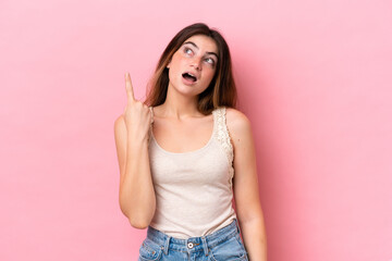 Young caucasian woman isolated on pink background intending to realizes the solution while lifting a finger up