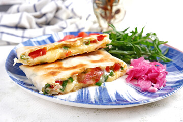 Tasty breakfast with quesadilla and eggs. Mexican cuisine. Trending food with pita bread, omelet, cheese, tomatoes