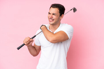 Young golfer player man isolated on pink background suffering from pain in shoulder for having made an effort