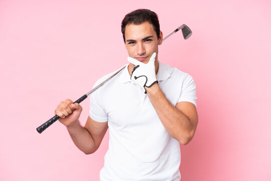 Young golfer player man isolated on pink background thinking