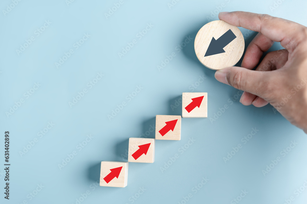 Fototapete Hand holding wood block with Black arrow and different direction facing opposite direction with red arrow for business disruption and technology transformation and different thinking idea concept.