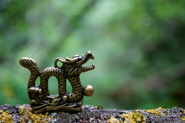 A metal dragon figurine and Chinese coins. Amulets and talismans.