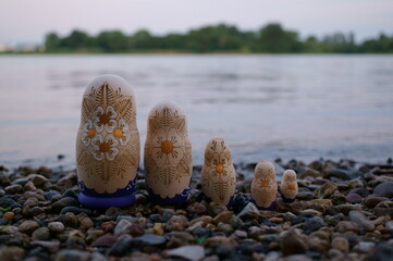 A group of nesting dolls on the river bank.