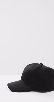 Vertical video of black baseball cap and copy space on white background