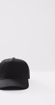 Vertical video of black baseball cap and copy space on white background