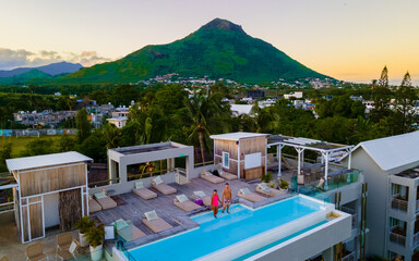 Man and Woman relaxing in a swimming pool watching sunset, a couple on a honeymoon vacation 