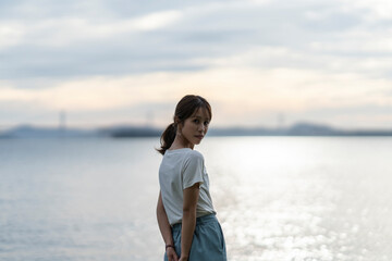 夕暮れの海にいる女性