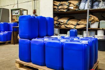Some of liquid containers standing on wooden pallet in warehouse storage of chemical liquids....