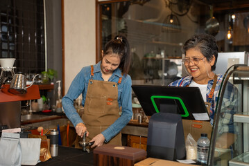 Asian lovely senior, elderly, retired, woman. Mother and her daughter working at her coffee shop. Small business, Business owner.