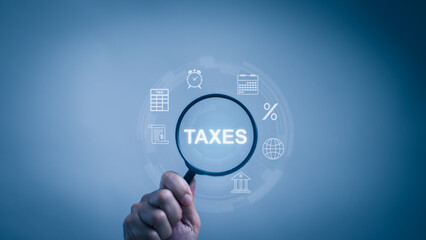 concept financial or income tax calculation online. ,Hand holding a magnifying glass labeled taxes...