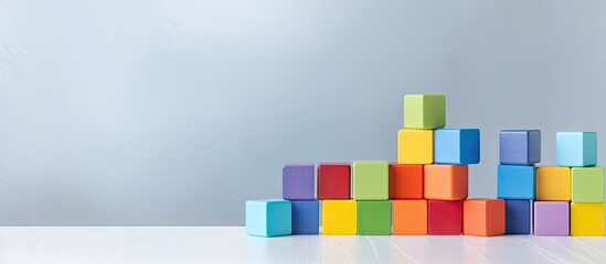 Colorful toy building blocks are displayed on a grey background with space to copy