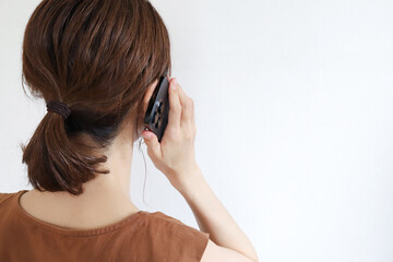 携帯電話で話す女性の後ろ姿