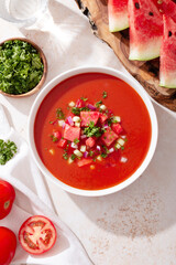 Spanish tomato and watermelon gazpacho cold soup styled and decorated in white plate