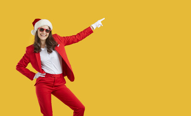 Joyful cheerful confident pretty young woman in stylish red suit, Christmas cap and trendy...