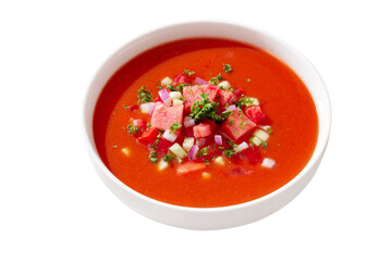 Isolated spanish tomato and watermelon gazpacho cold soup styled and decorated in white plate in hard light with shadows, top view