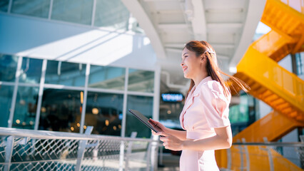 Shot of elegant young business woman smiling and  using tablet.