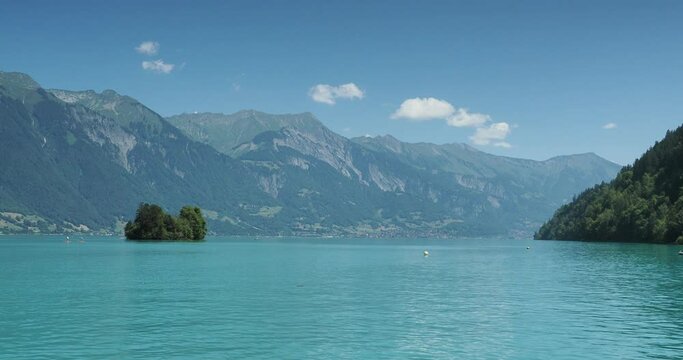 The Bay of Iseltwald and Turtle Island (Schneckeninsel) on Lake Brienz. Nautical activities, paddle on the waters facing the Emmental Alps, Brienz city  and Brienzer Rothorn on the horizon
