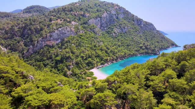 Turquoise water bay surrounded by green forest and hills in Gocek, Mugla TURKEY aerial footage summer sunny day