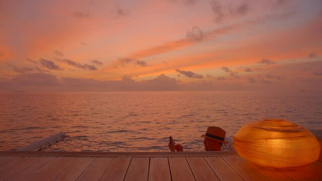 Man working on phone during tropical sunset