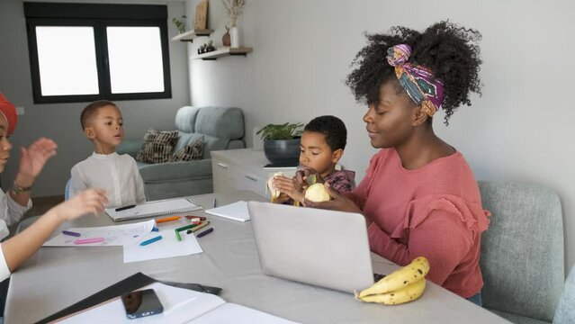 African family having a snack while painting or doing the homework. Horizontal extended family spending time together.