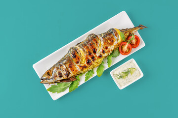 grilled mackerel with lemon and tomatoes on a green background for the menu, studio shooting