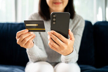 Shopping online input the serial number of credit card for payment. Young businesswoman holding credit card and cell phone