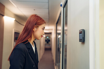 Businesswoman using face scanner to unlock door in office, Biometric admittance control device for...