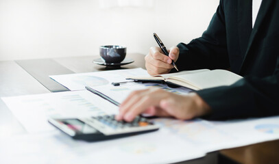 The business hand sits at their desks and calculates financial graphs showing the results of their investments planning the process of successful business growth