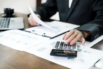 Fototapeta premium The business hand sits at their desks and calculates financial graphs showing the results of their investments planning the process of successful business growth