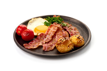 Cooked bacon rashers with egg, close-up, isolated on white background.