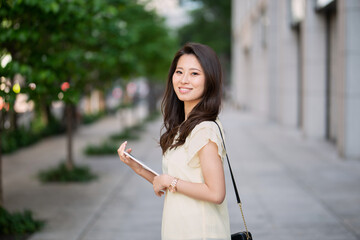 タブレットを持って微笑む女子大生