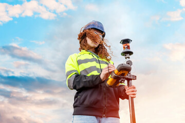 Female Woman land surveyor working with moder surveying geodesic instrument tachometer checking...