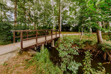 Eine holzerne Brücke erstreckt sich über einen Fluss in einem Park in Falkensee