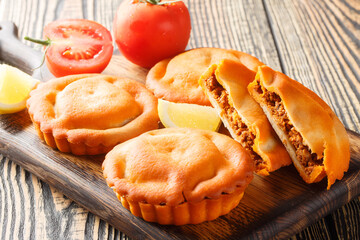 Tielle Setoise is a Octopus and Tomato pies from Sete closeup on a wooden board on the table. Horizontal