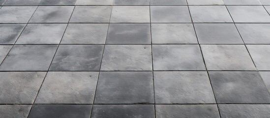 Rows and lines of square sidewalk tiles in a gray color are found on floors either outside or