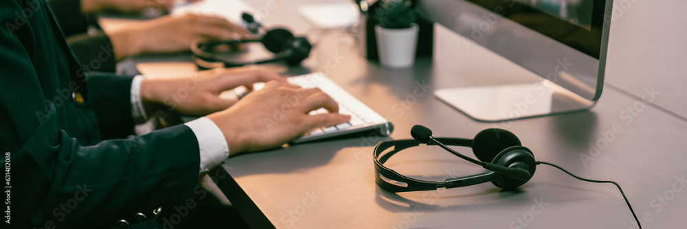 Aufkleber panorama focus headset on call center workspace desk with blur background of operator team or telesa