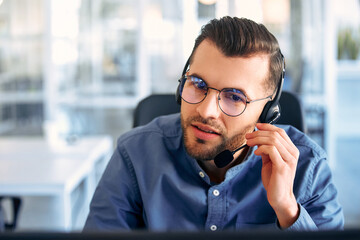 A call center worker sitting at a laptop in the office.