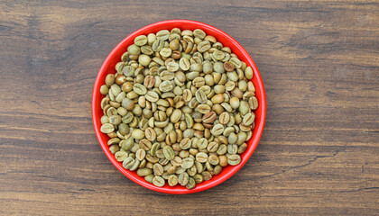 Green coffee beans in a plate top view 