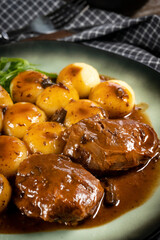 Traditional German braised pork cheeks in brown sauce.