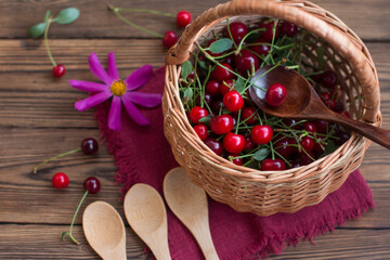 Ripe cherry berries in a bowl on the table with wooden spoons. Jam recipe